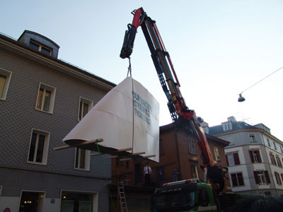 Tail Fin (upper part of an Jumbo-Jet's tail fin, 1:1) is lifted up to the terrasse of Perla-Mode by crane